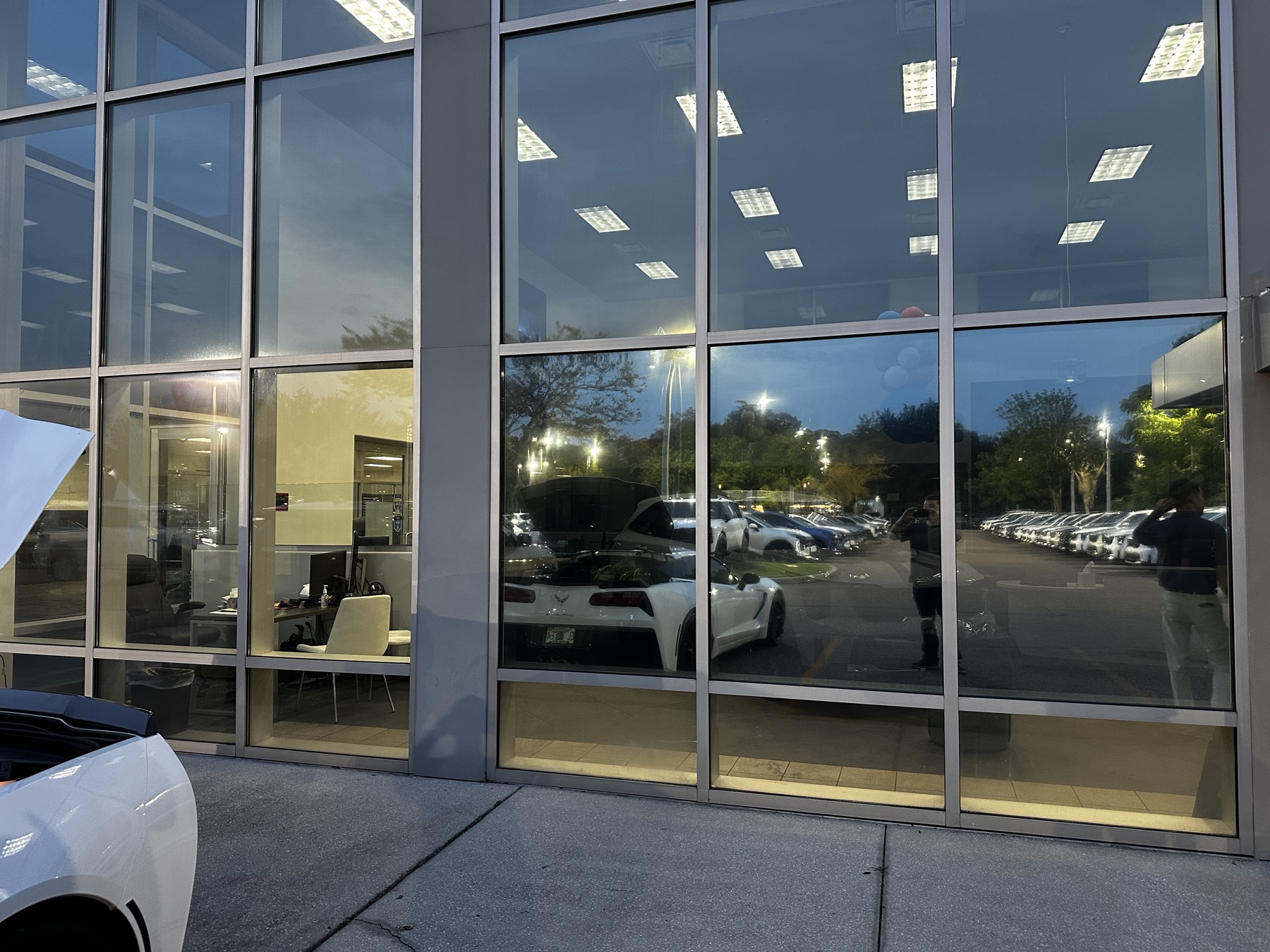 Dealership showroom at dusk with tinted glass